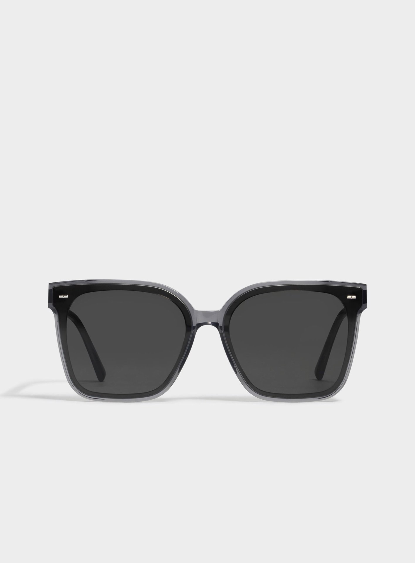 A pair of stylish Gentle Monster sunglasses placed on a white box with the brand name "Gentle Monster" printed on it.