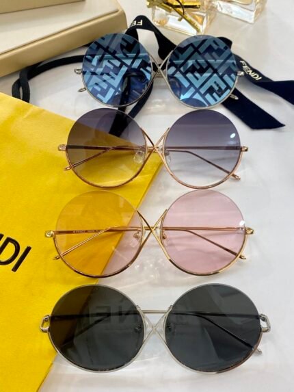The image displays a variety of stylish Fendi sunglasses with different lens colors, including blue, yellow, pink, and black. The sunglasses are placed on a white surface alongside a Fendi branded bag and a black ribbon, creating an elegant and luxurious presentation.