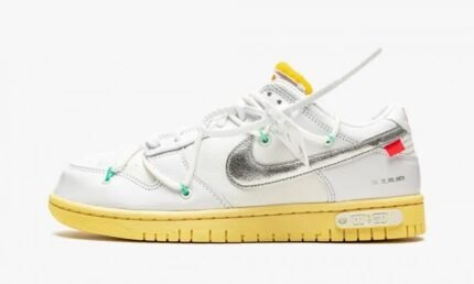 English: White sneakers with yellow soles, silver logo, green eyelets