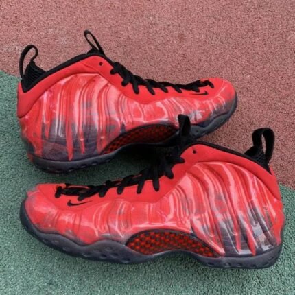 A pair of red sports shoes with black laces and a black sole