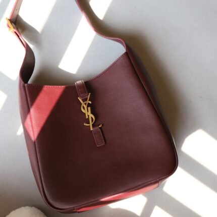 Red handbag with a gold letter logo.