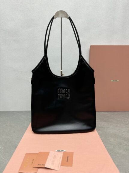 Black shopping bag with brand logo, pink background, and brand cards