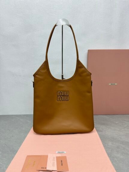 Brown shopping bag with brand logo, pink background, and brand cards