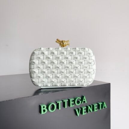 Light green woven leather clutch with a golden knot detail.