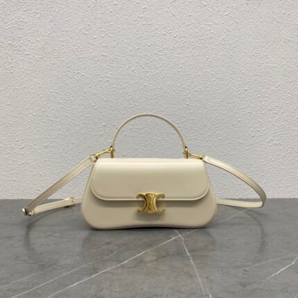 Off-white leather handbag with gold lock, on a grey marble background