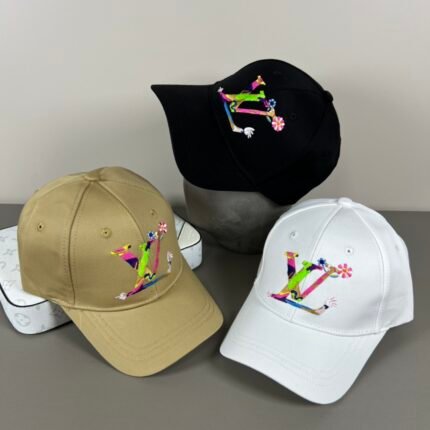 Three hats in black, gold, and white colors, each with a colorful pattern, set against a white background.