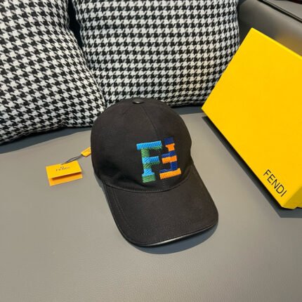 A black cap with a colorful letter pattern, placed next to a yellow box.